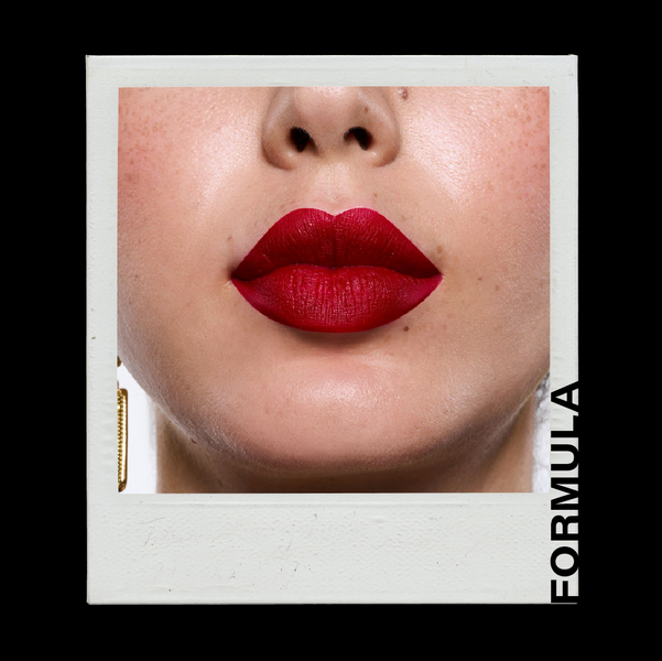 Close-up of red lipstick on lips with 'Formula' branding.